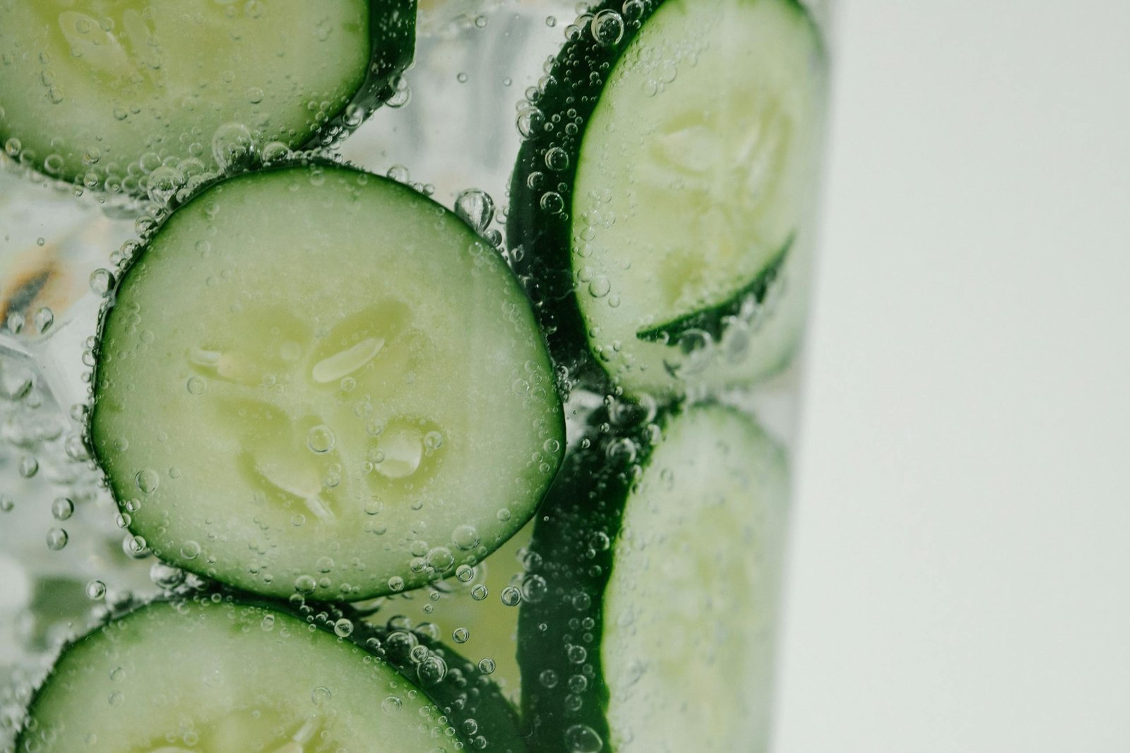Close-up of cucumber slices in sparkling water, highlighting freshness and refreshment.