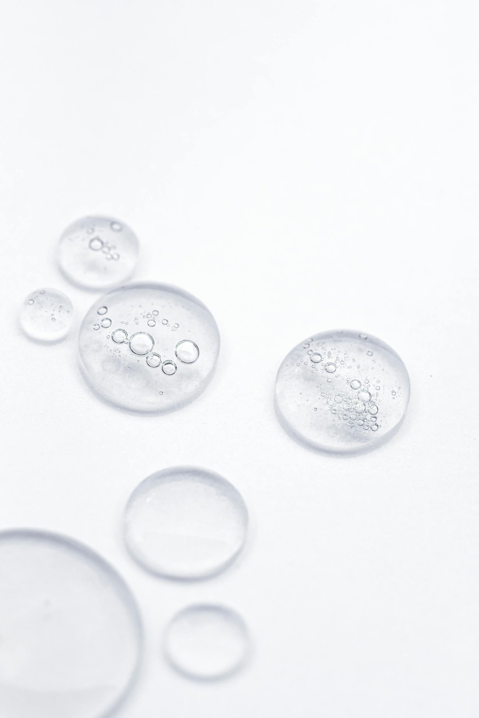 Fresh and vibrant close-up of water droplets on a white background, symbolizing purity and hydration.