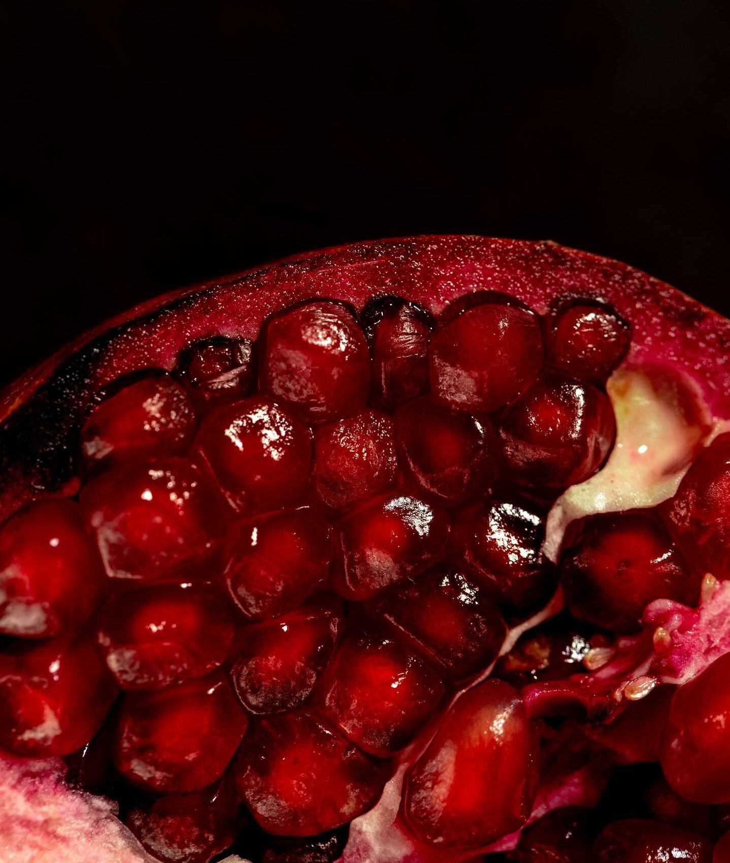 Vivid close-up of juicy red pomegranate seeds showcasing their natural texture and freshness.