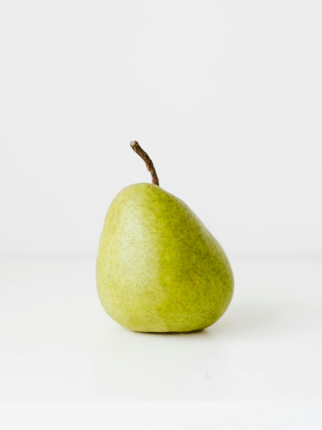 A simple and elegant image of a fresh pear against a white background, perfect for healthy living concepts.