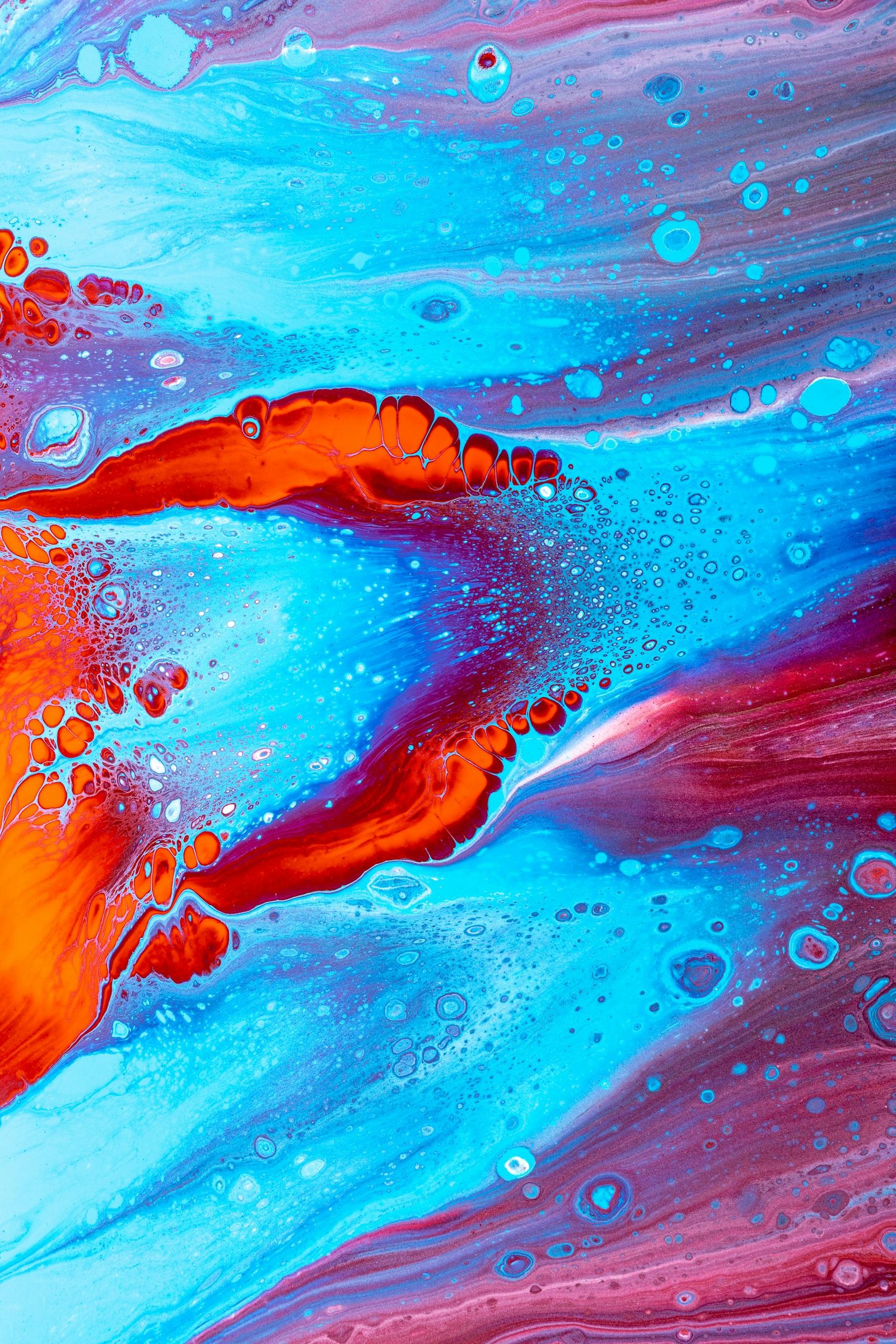 Vibrant abstract fluid painting in blue and red hues, showcasing dynamic motion and texture.