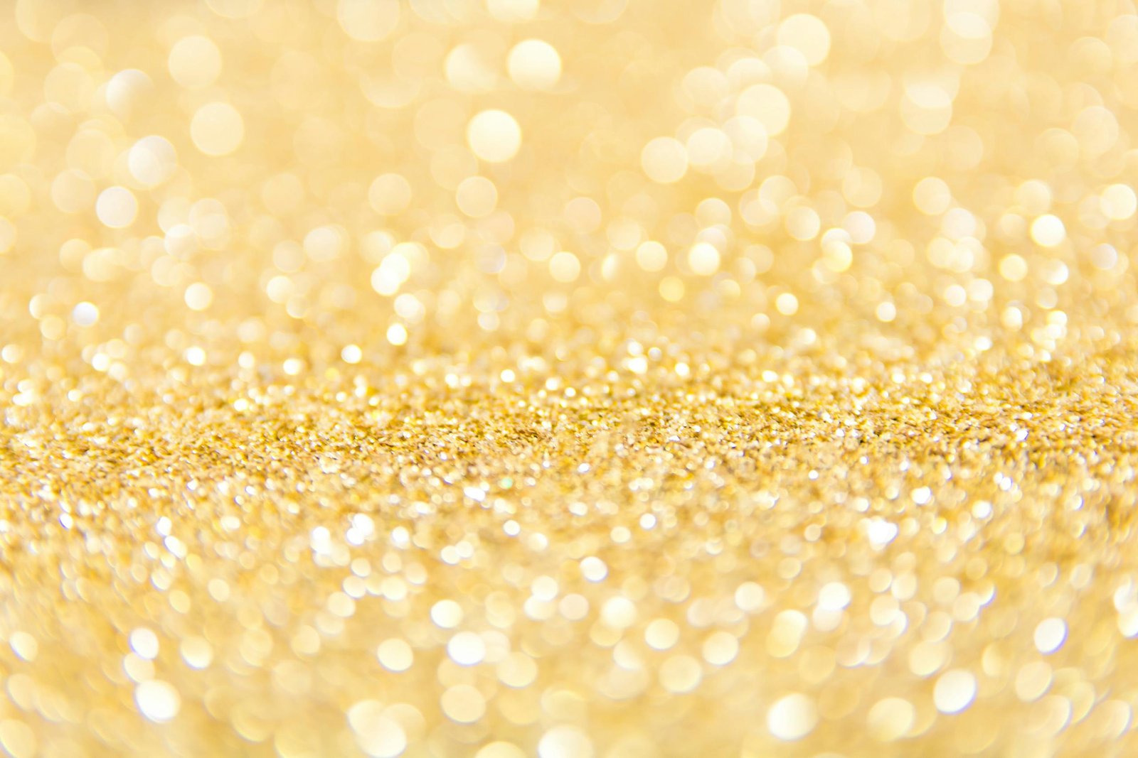 Abstract gold glitter background with a bokeh effect, ideal for festive designs.